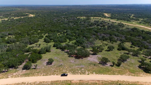 an aerial view of mountains with green space and fog
