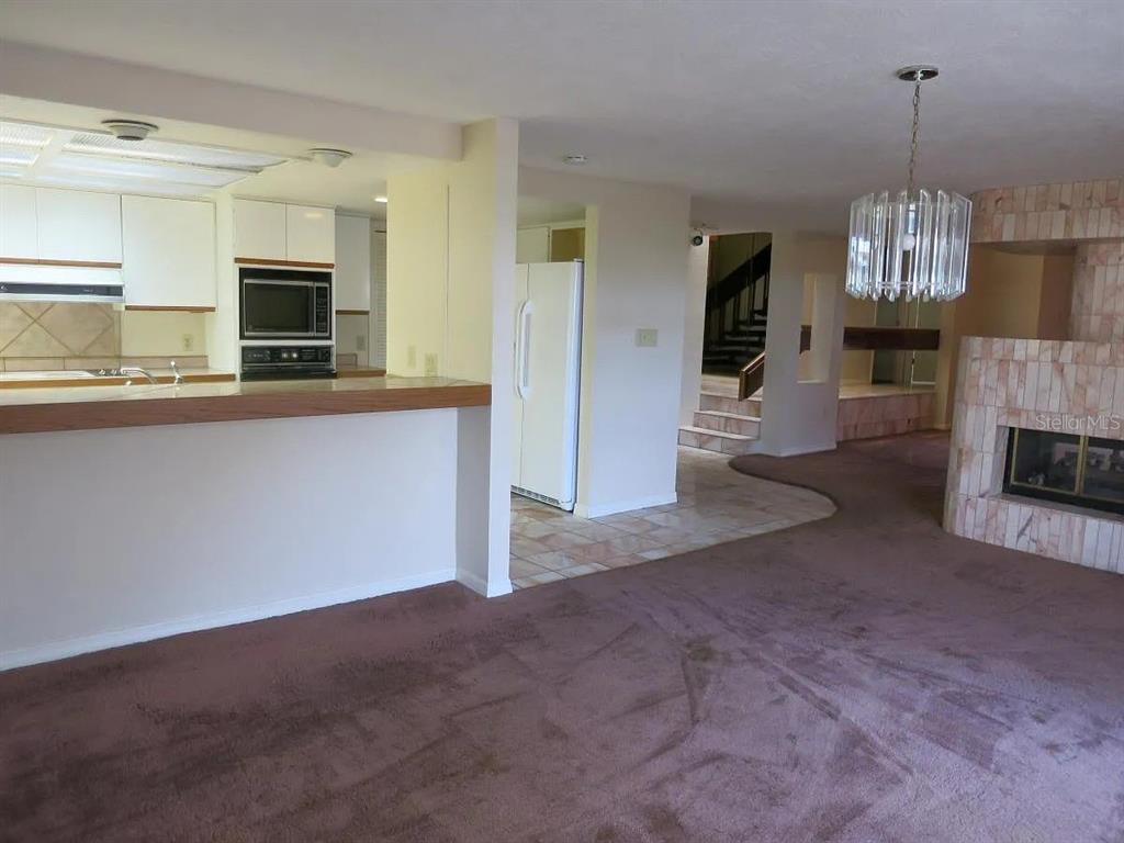 17 Casarena Court Winter Haven, FL 33881 - Photo 12 of 13 a view of empty room with kitchen view and fireplace
