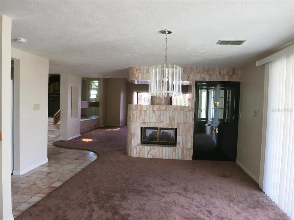 17 Casarena Court Winter Haven, FL 33881 - Photo 8 of 13 a view of a livingroom with a fireplace a chandelier and windows