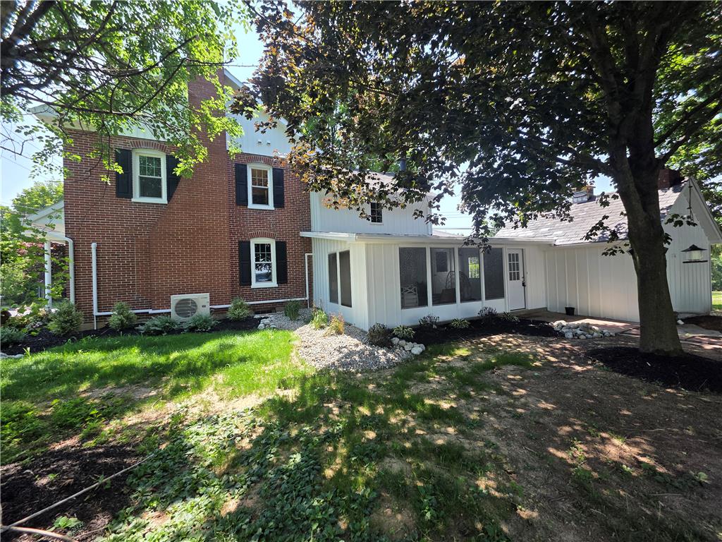 Brick and white siding provide charming contrast for this home's exterior with a verdant yard.