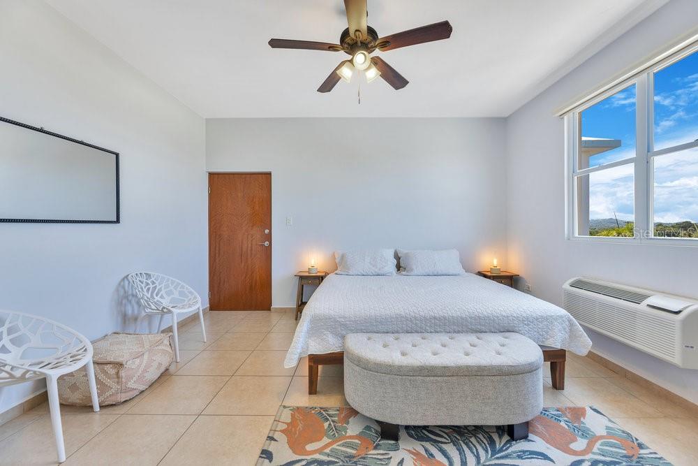 413 Camino Carretas, Unit A7 Rincon, Rincón 00677 - Photo 13 of 23 a bedroom with a bed dresser and a window