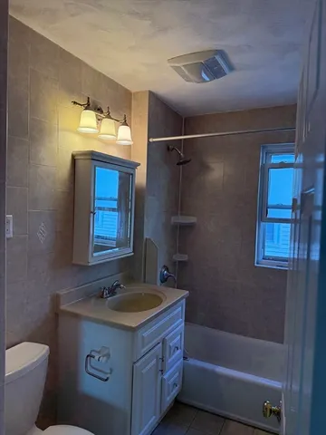 a bathroom with a granite countertop sink a mirror and a bathtub
