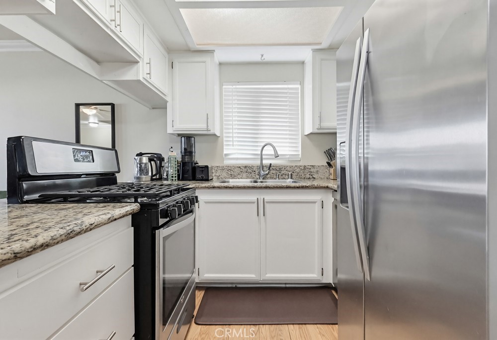 13470 Meyer Road, Unit 22 Whittier, CA 90605 - Photo 15 of 50 a kitchen with stainless steel appliances granite countertop a sink stove and refrigerator