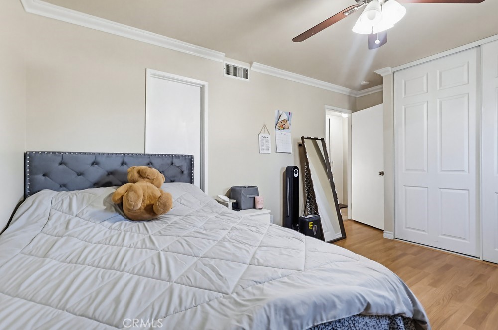 13470 Meyer Road, Unit 22 Whittier, CA 90605 - Photo 25 of 50 a bedroom with a bed and a chandelier