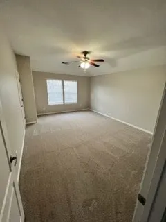 an empty room with a ceiling fan and window