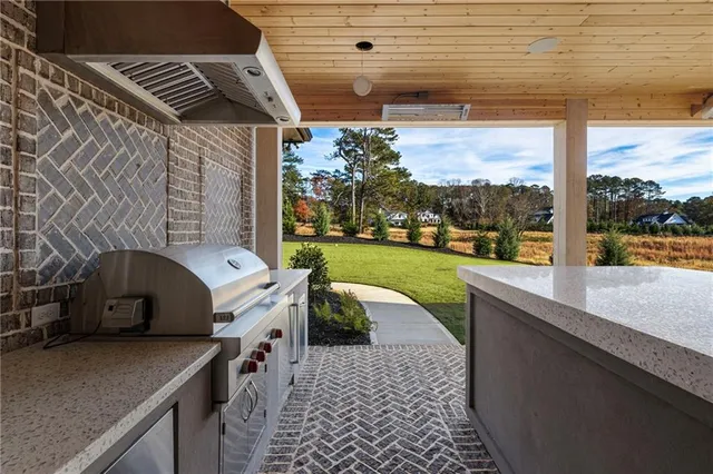 a large white kitchen with a stove a sink dishwasher and a refrigerator with wooden floor