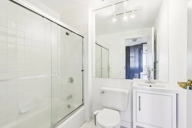 a bathroom with a sink a toilet and shower