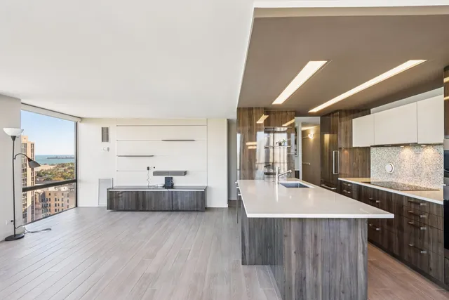 a kitchen with kitchen island a large counter top space a sink stainless steel appliances and cabinets
