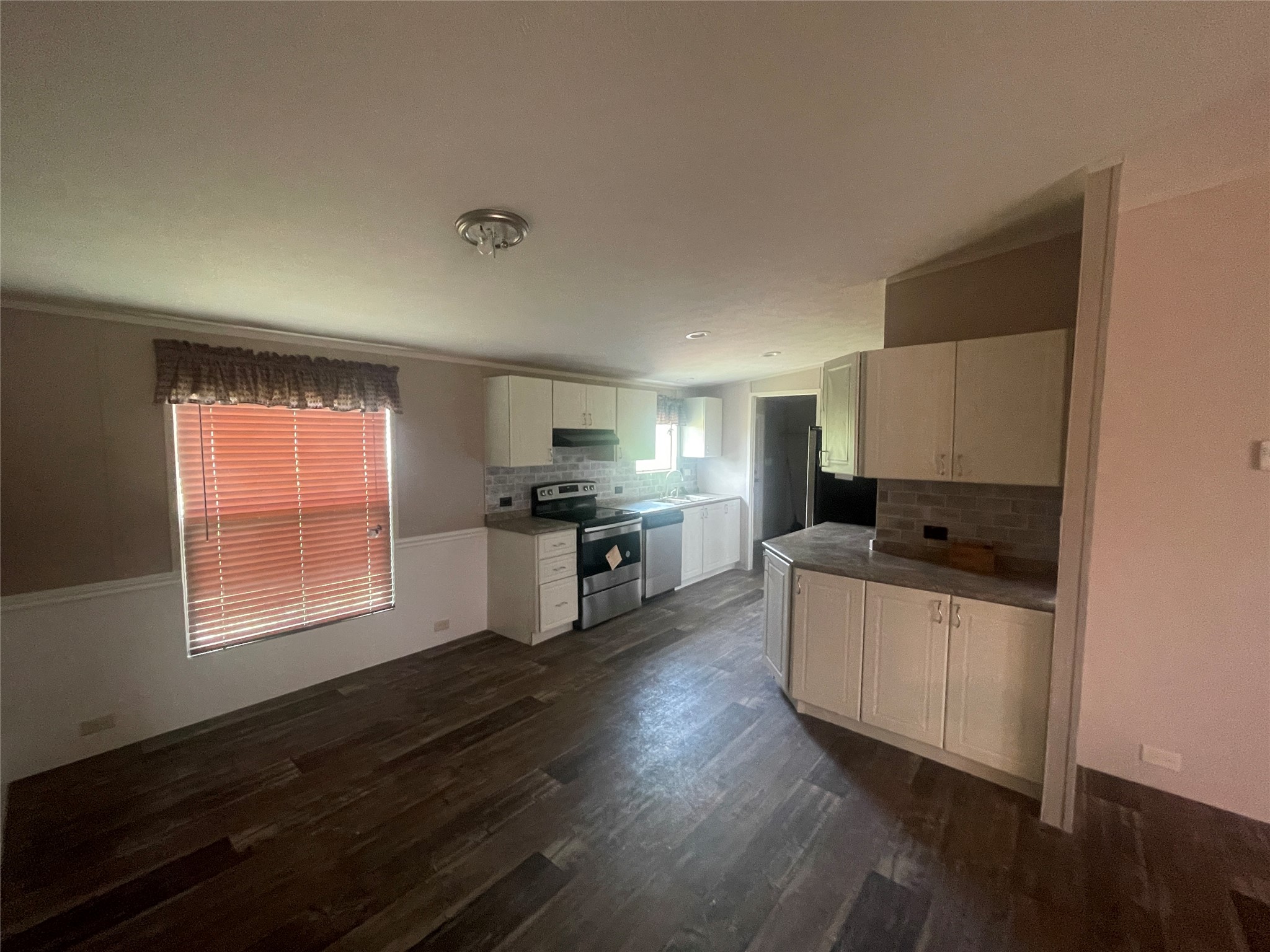 7855 Taylorsville Road Dale, TX 78616 - Photo 5 of 12 A well-equipped culinary space boasts stainless steel appliances and wood flooring.