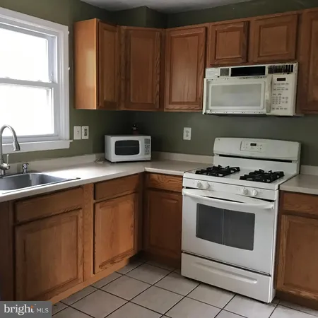a kitchen with granite countertop white cabinets and white appliances