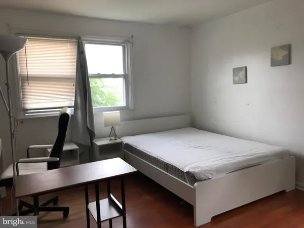 a bedroom with a bed a desk and chair