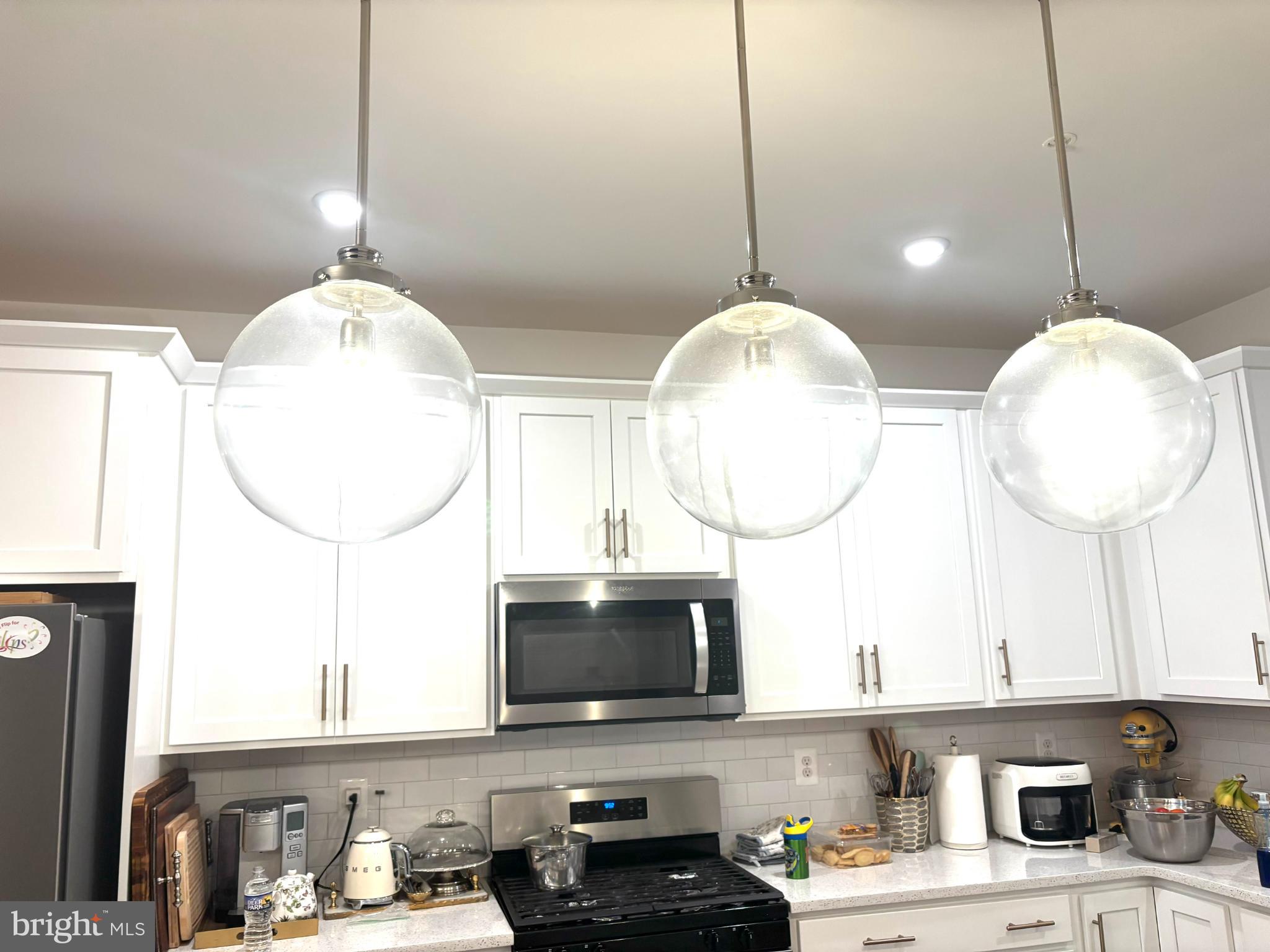 a kitchen with a sink a microwave a stove and cabinets