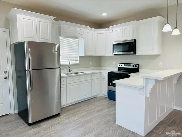 a view of kitchen with stainless steel appliances granite countertop cabinets and wooden floor