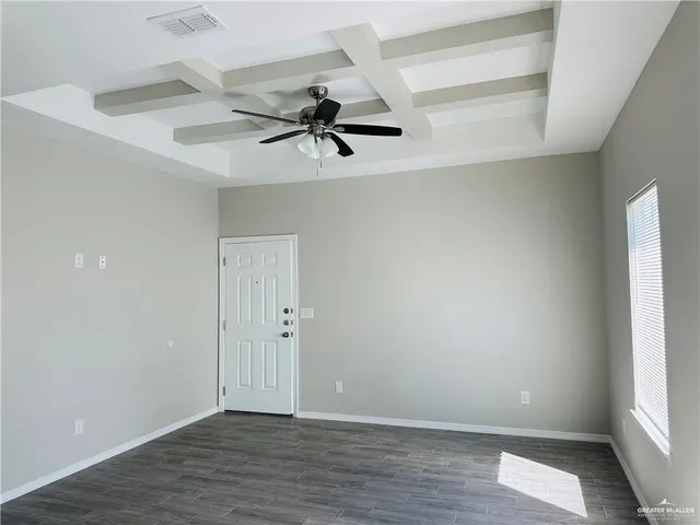 an empty room with a window and a ceiling fan