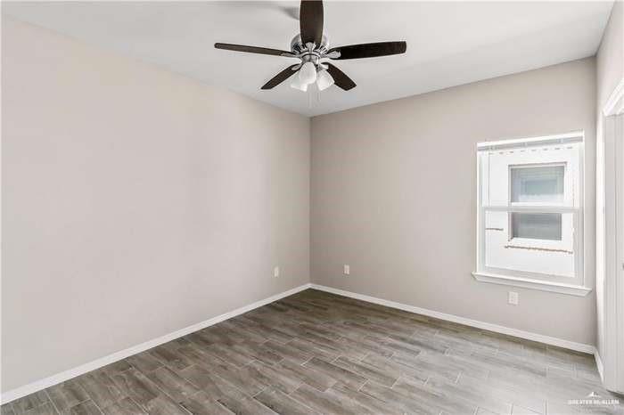 1614 Playa Drive, Unit 2 Weslaco, TX 78596 - Photo 5 of 8 an empty room with a window and a ceiling fan