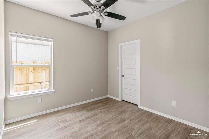 1614 Playa Drive, Unit 2 Weslaco, TX 78596 - Photo 6 of 8 an empty room with a window and ceiling fan