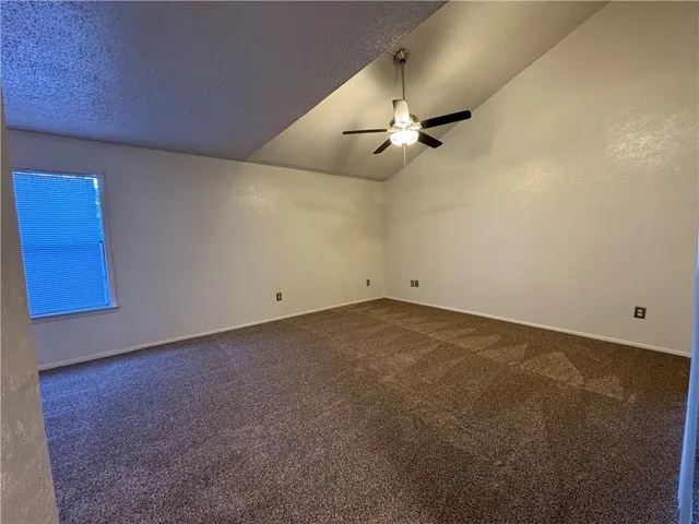 an empty room with a ceiling fan and a window