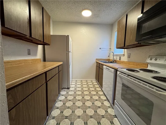 a kitchen with stainless steel appliances a sink stove and microwave
