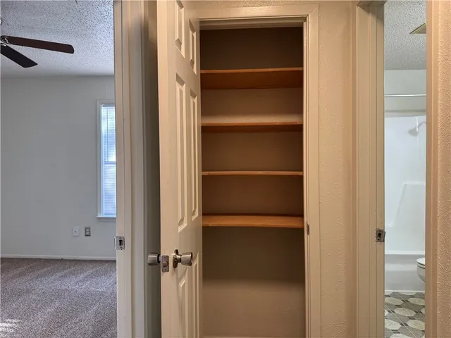 a view of walk in closet with empty racks