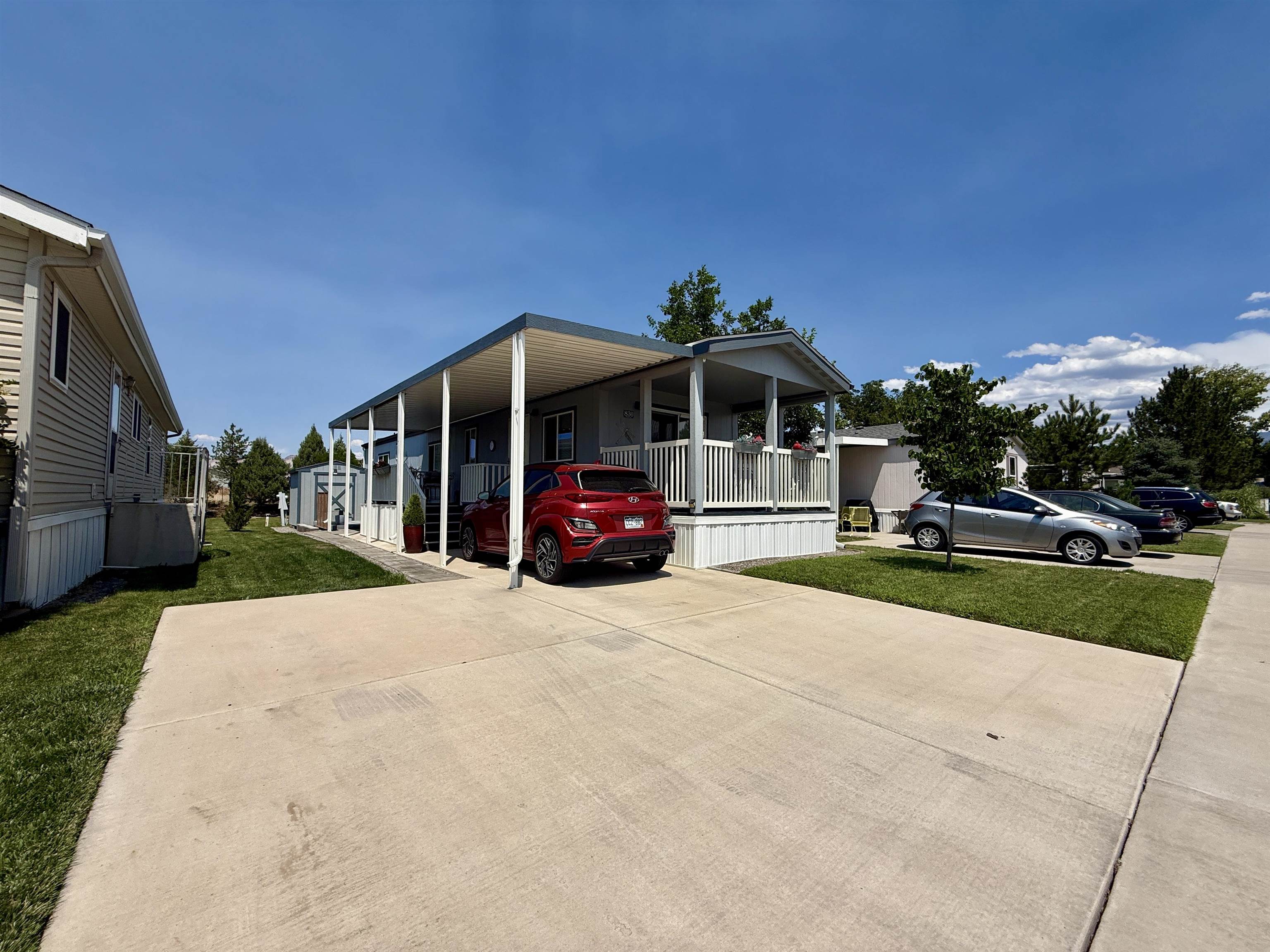 a front view of a house with a yard and car parked