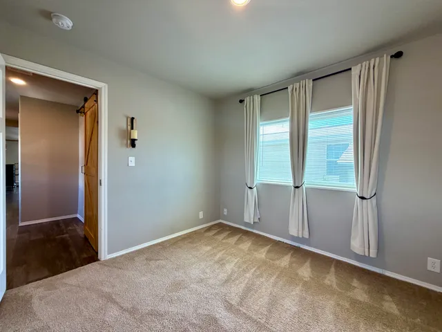 a view of an empty room with window and closet area