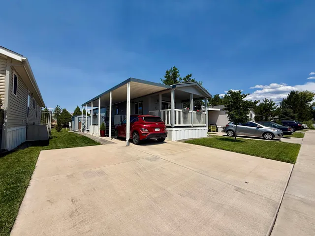 a front view of a house with a yard and car parked