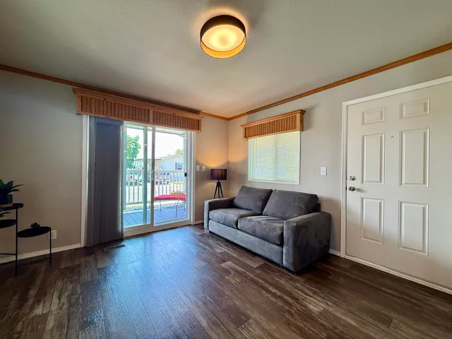 a living room with couches and a large window with wooden floor