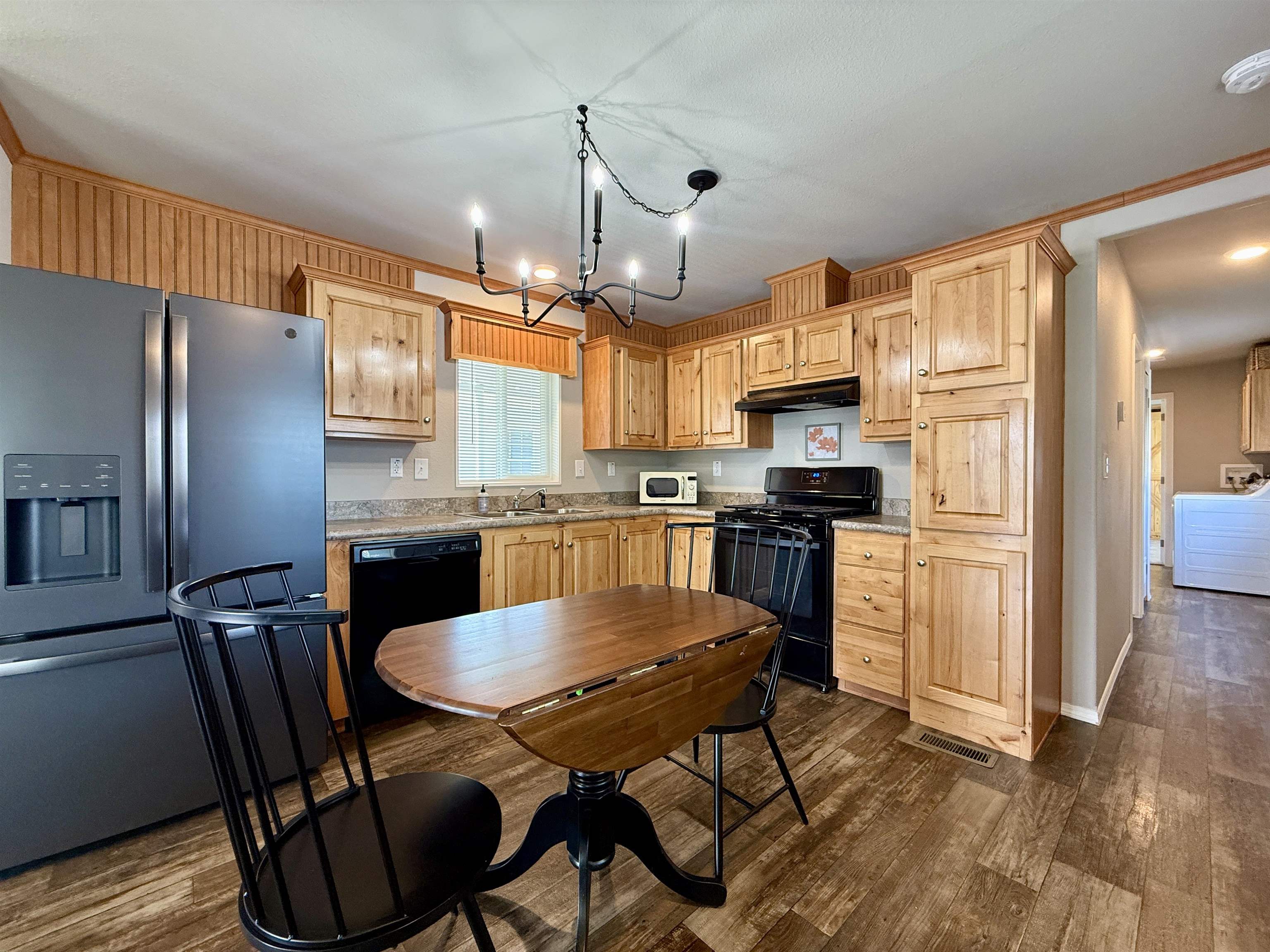 435 32 Road, Unit 830 Clifton, CO 81520 - Photo 10 of 28 a kitchen with stainless steel appliances granite countertop a refrigerator a stove a sink dishwasher a dining table and chairs with wooden floor