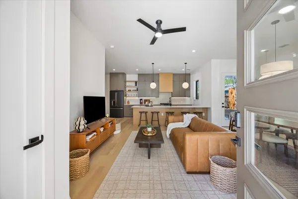 a living room with furniture a flat screen tv and kitchen view