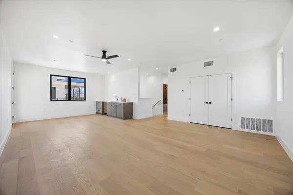 a view of a big room with wooden floor and windows