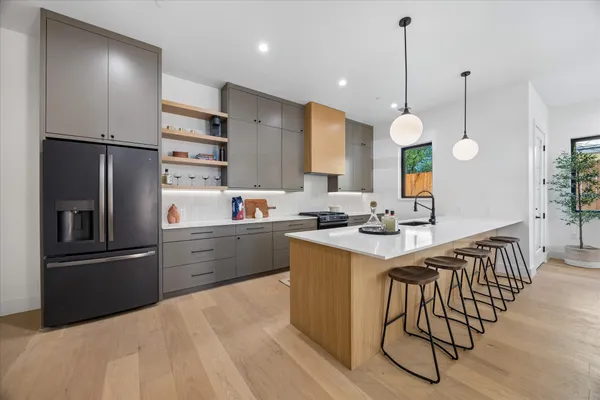a large white kitchen with a large counter top appliances and cabinets