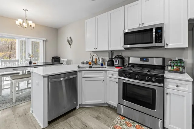 a kitchen with white cabinets stainless steel appliances and sink