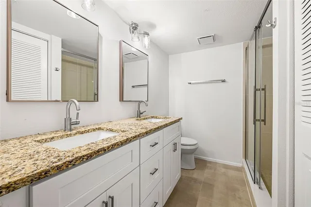 a bathroom with a granite countertop sink toilet and shower
