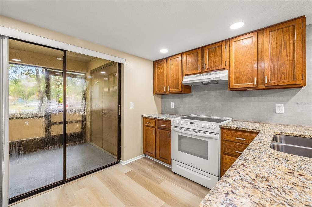 125 Woodlake Wynde Oldsmar, FL 34677 - Photo 10 of 20 a kitchen with stainless steel appliances granite countertop a refrigerator a stove and a sink with wooden cabinets