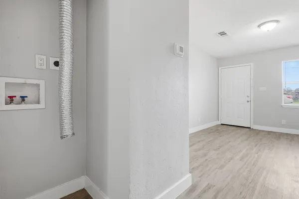 a view of an empty room with wooden floor