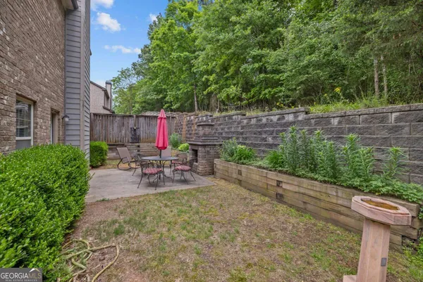 a view of a patio with table and chairs potted plants with wooden fence