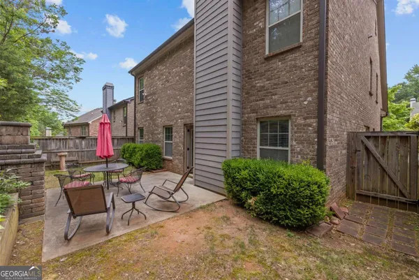 a patio with a table and chairs and a barbeque
