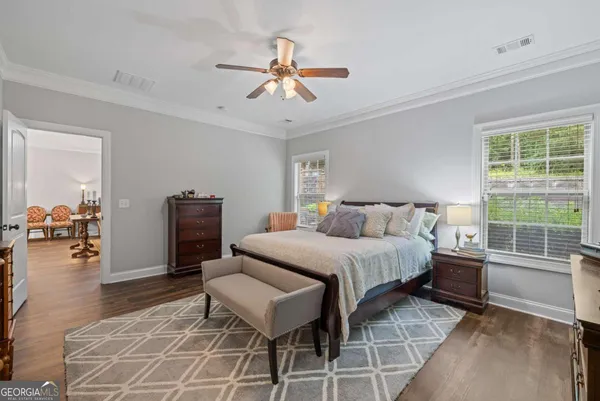 a kitchen with stainless steel appliances kitchen island granite countertop a refrigerator a stove top oven a sink dishwasher and white cabinets with wooden floor