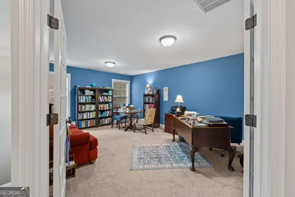 a reading room with furniture rug and a bookshelf