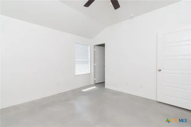 an empty room with closet and a ceiling fan
