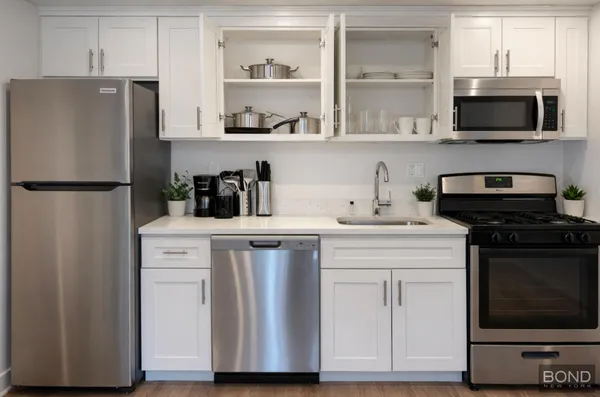 a kitchen with stainless steel appliances a refrigerator stove and microwave