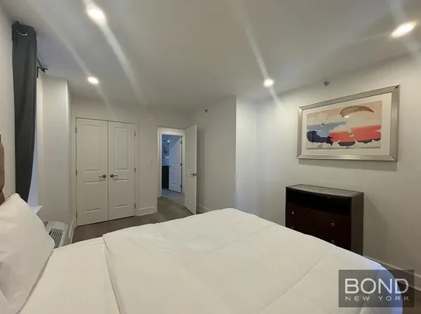 a bedroom with a bed and a painting on the wall