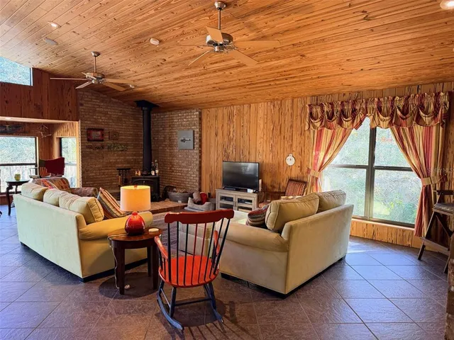 a bedroom with a bed a table and chair with the large mirror