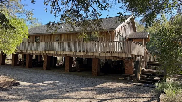 a view of deck with wooden floor and fence with a bench