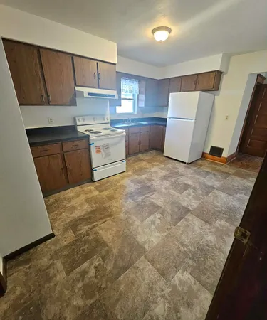 a kitchen with a refrigerator sink and cabinets