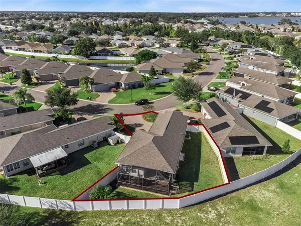 an aerial view of a house with a yard and lake view