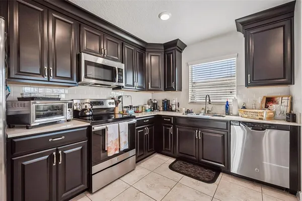 a kitchen with stainless steel appliances granite countertop a stove microwave and sink