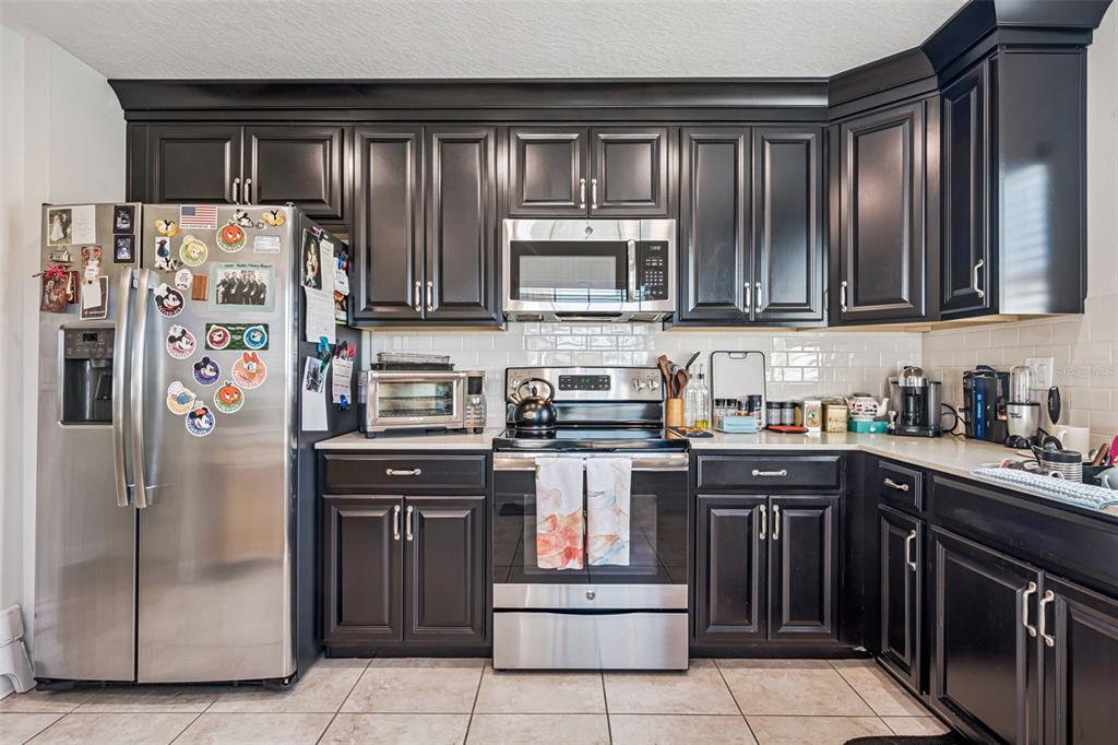 3365 Raleigh Drive Winter Haven, FL 33884 - Photo 9 of 39 a kitchen with stainless steel appliances granite countertop a stove and a refrigerator