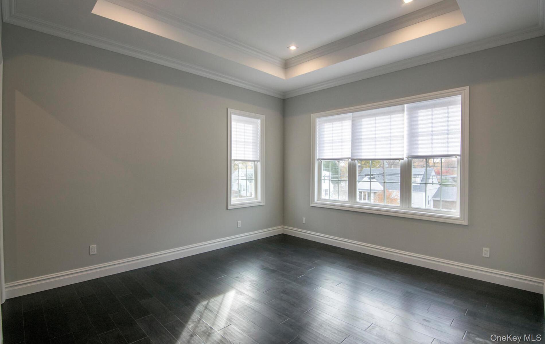 2 Seaman Road Glen Cove, NY 11542 - Photo 4 of 15 an empty room with wooden floor and windows