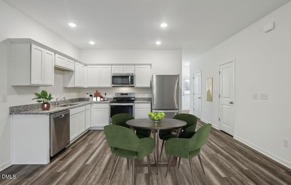 2139 Gln Xing Drive Durham, NC 27704 - Photo 9 of 20 a kitchen with white cabinets and stainless steel appliances